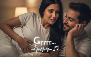 A couple lies in bed during an intimate moment. The woman has a slightly embarrassed expression as a transparent, comical "rumbling" sound wave emanates from her stomach, while the man smiles, finding the sound amusing.